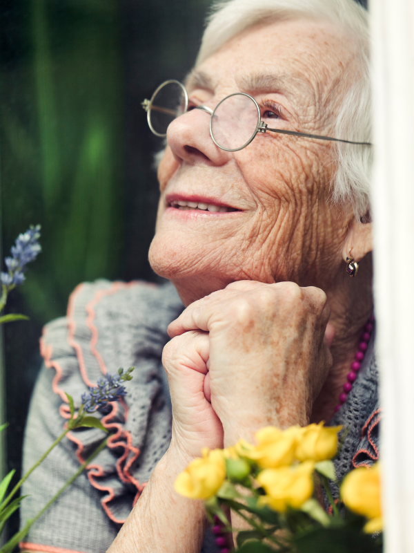 older lady with flowers smiling hopefully