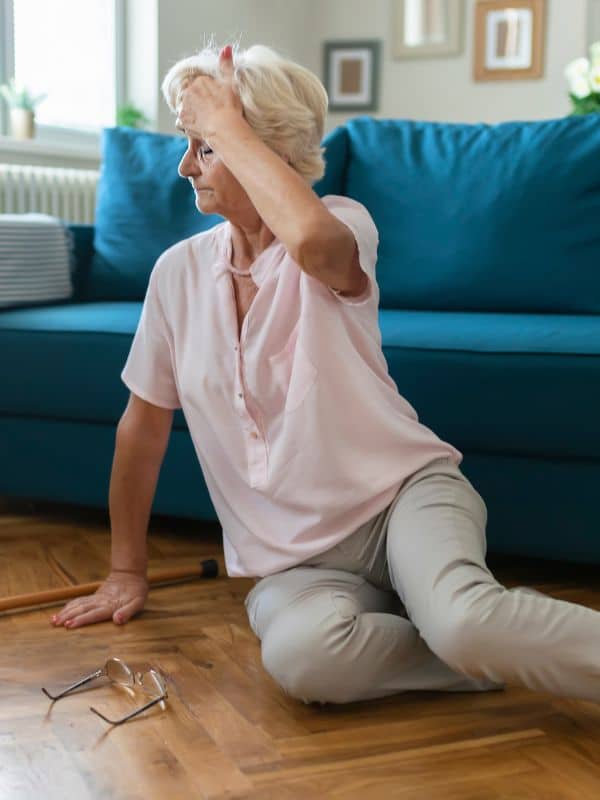 an elderly woman who has fallen in her living room